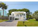 Inviting two-story home featuring a well-maintained yard and a classic white facade at 2407 Cameron Blvd, Isle of Palms, SC 29451