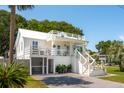 Elegant two-story white house with a deck, screened-in porch, and well-manicured lawn at 2407 Cameron Blvd, Isle of Palms, SC 29451