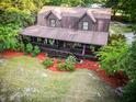 Aerial shot of log cabin with covered porch, landscaped yard, and inviting outdoor space at 24678 Augusta Hwy, Cottageville, SC 29435