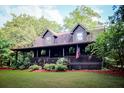 Quaint log home with cozy covered porch and decorative foliage for country living at 24678 Augusta Hwy, Cottageville, SC 29435