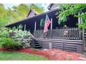 Inviting log home porch with railing and decorative plants creating a relaxing outdoor space at 24678 Augusta Hwy, Cottageville, SC 29435