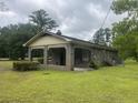Side view of a brick house with a lattice trimmed covered porch, and a lush green lawn at 379 Chestnut Rd, Walterboro, SC 29488