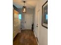 Inviting entryway with hardwood floors, neutral paint, stylish lighting, and decorative cabinet and artwork at 3808 Tupelo Branch Row, Mount Pleasant, SC 29429
