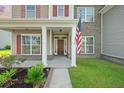 Inviting front porch with detailed columns and an American flag at 438 Flat Rock Ln, Summerville, SC 29486