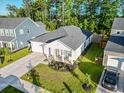 Aerial view of a well-maintained home with lush lawn, landscaped garden, and driveway leading to attached garage at 4407 Palm Shadow Dr, Summerville, SC 29485