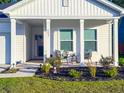 Charming front porch with cozy seating, manicured garden beds, and freshly cut grass creating a welcoming entrance at 4407 Palm Shadow Dr, Summerville, SC 29485
