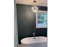 Contemporary bathroom featuring a standalone tub, large window, and stylish chandelier at 5513 Blackwell Ave # B, North Charleston, SC 29406
