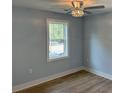 Bright bedroom with modern ceiling fan, new vinyl floors, base trim, and window at 5513 Blackwell Ave # B, North Charleston, SC 29406