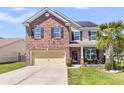 Charming two-story brick home with a two-car garage, manicured lawn, and a welcoming front porch at 7644 High Maple Cir, North Charleston, SC 29418