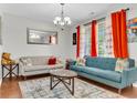 Inviting living room boasts hardwood floors, stylish furnishings, and ample natural light from large windows at 7644 High Maple Cir, North Charleston, SC 29418