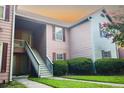 Two-story condo with wooden exterior and stairway, surrounded by lush greenery at 7950 Parklane Ct # C, North Charleston, SC 29418