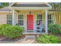 Inviting front porch with a bright red door, comfortable seating, and charming decorative touches at 1004 Providence Way, Summerville, SC 29483