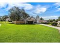 Sprawling front yard with lush green grass and mature trees adds to the home's curb appeal at 1034 Steelechase Ln, Hanahan, SC 29410