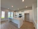 Bright kitchen boasts a large center island, white cabinets, and modern stainless-steel appliances at 1051 Scotch Bonnet Way, Summerville, SC 29485