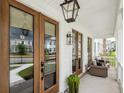 Inviting front porch with comfortable seating, pendant lighting and double doors at 1244 Crooked Oak Rd, Charleston, SC 29492