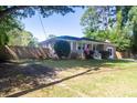 Well-kept brick home with a neat lawn, an American flag, and a wooden privacy fence at 1261 Hampshire Rd, Charleston, SC 29412