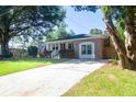 Brick home with a well-manicured lawn, an American flag, and a paved driveway at 1261 Hampshire Rd, Charleston, SC 29412