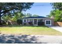 Classic brick home featuring a lush green lawn, mature trees, and a paved driveway at 1261 Hampshire Rd, Charleston, SC 29412