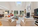 Sun-filled living room with vaulted ceilings, fireplace, and serene views of the backyard at 132 Turnberry Dr, Johns Island, SC 29455