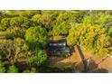 Aerial view showcases the property nestled among mature trees, surrounded by a fenced yard at 1518 Southwick Dr, Johns Island, SC 29455