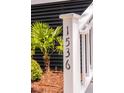Close-up of house number 1536 on a white post with lush green plants and mulch around at 1536 Keshi Pearl Dr, Mount Pleasant, SC 29466