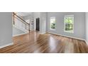 Inviting living room featuring wood floors, staircase, and abundant natural light from large windows at 170 Highwoods Plantation Ave, Summerville, SC 29485
