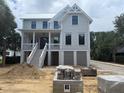 Two-story home featuring a classic design, inviting front porch, and construction materials at 1727 Atlantic Ave, Sullivans Island, SC 29482