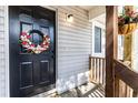 Close-up of a black front door with a spring wreath and a hanging flower basket at 19 Rudwick Cir, Goose Creek, SC 29445