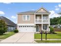 Charming two-story home with manicured lawn, a front porch, a balcony and a two-car garage at 200 Topsaw Ln, Moncks Corner, SC 29461