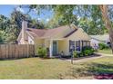 Exterior view of a light yellow home with a light blue door, a well-kept lawn, and a light post at 2076 Presidio Dr, Mount Pleasant, SC 29466
