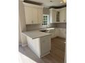 Well-lit kitchen with white cabinets, quartz countertops, and stainless steel appliances at 308 Tidal Rice Ct, Wando, SC 29492