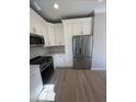 Modern kitchen featuring stainless steel appliances and sleek white cabinetry at 308 Tidal Rice Ct, Wando, SC 29492