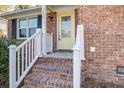 Close up of a brick home front entrance featuring a yellow door with glass insert and white railed brick steps at 3627 Marginal Rd, Mount Pleasant, SC 29466
