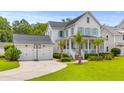 Inviting two-story home with a detached garage, a basketball hoop, and a lush green lawn at 3870 Fifle St, Mount Pleasant, SC 29466