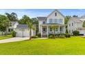 Beautiful two-story home with a detached garage, well-manicured lawn, and inviting front porch at 3870 Fifle St, Mount Pleasant, SC 29466