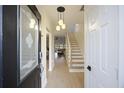 Inviting foyer with stylish lighting, wood floors and staircase leading to upper level at 4789 Arco Lane Ln, North Charleston, SC 29418
