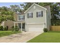 Inviting two-story home featuring green siding, a two-car garage, and a well-maintained front yard at 4949 Serene Ln, Hollywood, SC 29449