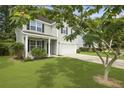 Beautiful two-story home with a well-kept lawn, charming front porch, and convenient two-car garage at 4949 Serene Ln, Hollywood, SC 29449