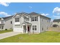 Two-story home featuring gray siding, a well-manicured lawn, and an attached garage at 613 Ravens Wood Rd, Summerville, SC 29486