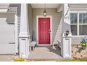 Inviting front porch with red door, white pillars, and bench seating at 613 Ravens Wood Rd, Summerville, SC 29486