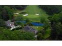 An aerial view of a cozy house in a neighborhood, with a pond, fountain, and golf course in the background at 806 Westos Way, Mount Pleasant, SC 29464