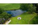 A pond, fire pit, seating, and lush green grass create the perfect backyard for this charming home at 806 Westos Way, Mount Pleasant, SC 29464
