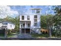 Charming two-story home with a white exterior, staircase, and a well-manicured lawn at 814 Palm Blvd, Isle of Palms, SC 29451