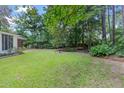 Lush backyard showcasing a manicured lawn, trees, birdbath, and a charming swing, perfect for relaxation and recreation at 112 Roselle Ave, Goose Creek, SC 29445