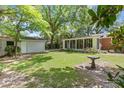 Backyard with a well-maintained lawn, shade trees, and a detached garage, creating a serene outdoor space at 112 Roselle Ave, Goose Creek, SC 29445