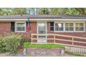 Charming brick home featuring a welcoming front door, a ramp, and an American flag at 112 Roselle Ave, Goose Creek, SC 29445
