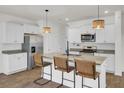 Modern kitchen with stainless steel appliances, granite countertops, an island with bar seating, and stylish lighting at 138 Sweet Cherry Ln, Summerville, SC 29486