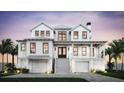 Stunning two-story home exterior with double garages, a grand staircase, and covered front porch at 2879 Marshall Blvd, Sullivans Island, SC 29482