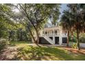 A beautiful coastal home surrounded by lush green landscaping and mature trees creating an inviting ambiance at 2911 Old Tavern Ct, Mount Pleasant, SC 29466