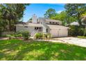 Charming two-story home with a two-car garage, surrounded by mature trees and lush greenery at 3 Sand Dollar Dr, Isle of Palms, SC 29451